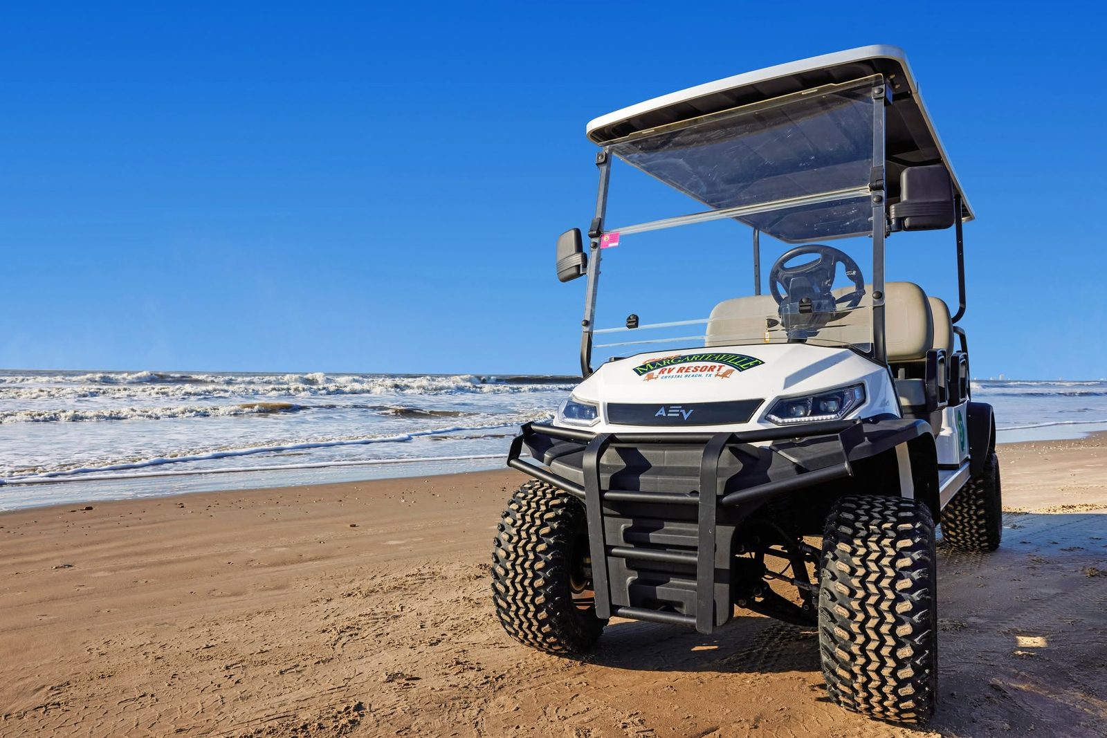 A Margaritaville RV Resort cart parked on the sand at Crystal Beach
