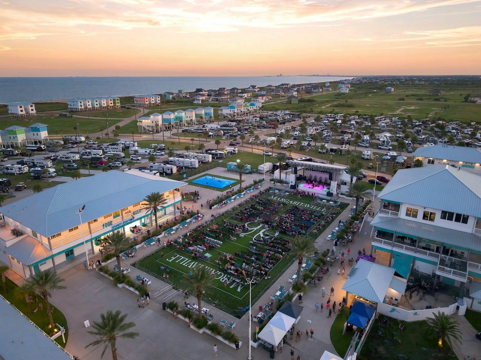 Aerial view of Camp Margaritaville RV Resort at sunset, with RV sites, cottages, and the Gulf